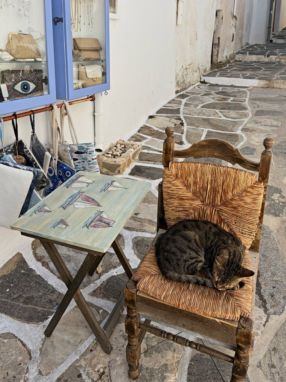 A cat asleep on a rush chair in a whitewashed lane, Paros