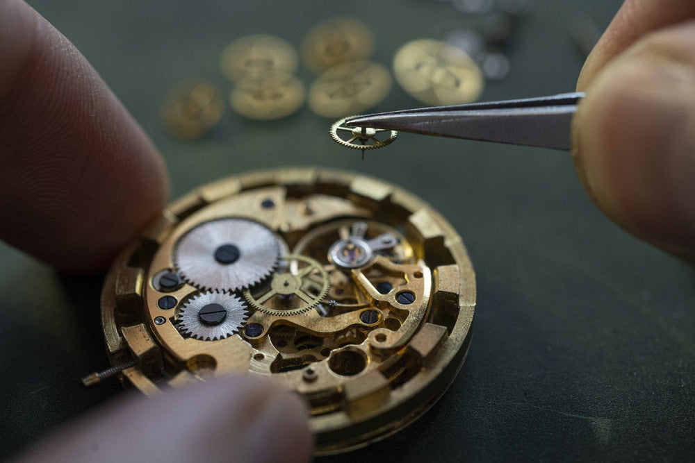 A watch movement being assembled by hand