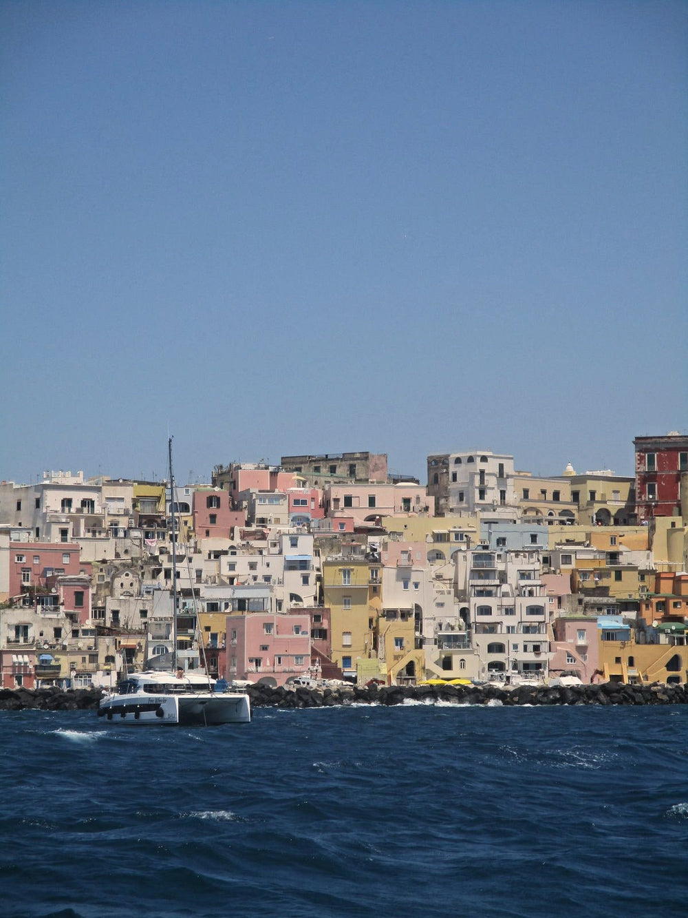 Pastel houses stacked above an island harbour