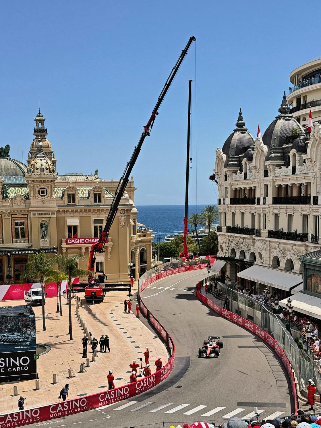 A Formula 1 car through Casino Square in Monte-Carlo, the sea beyond