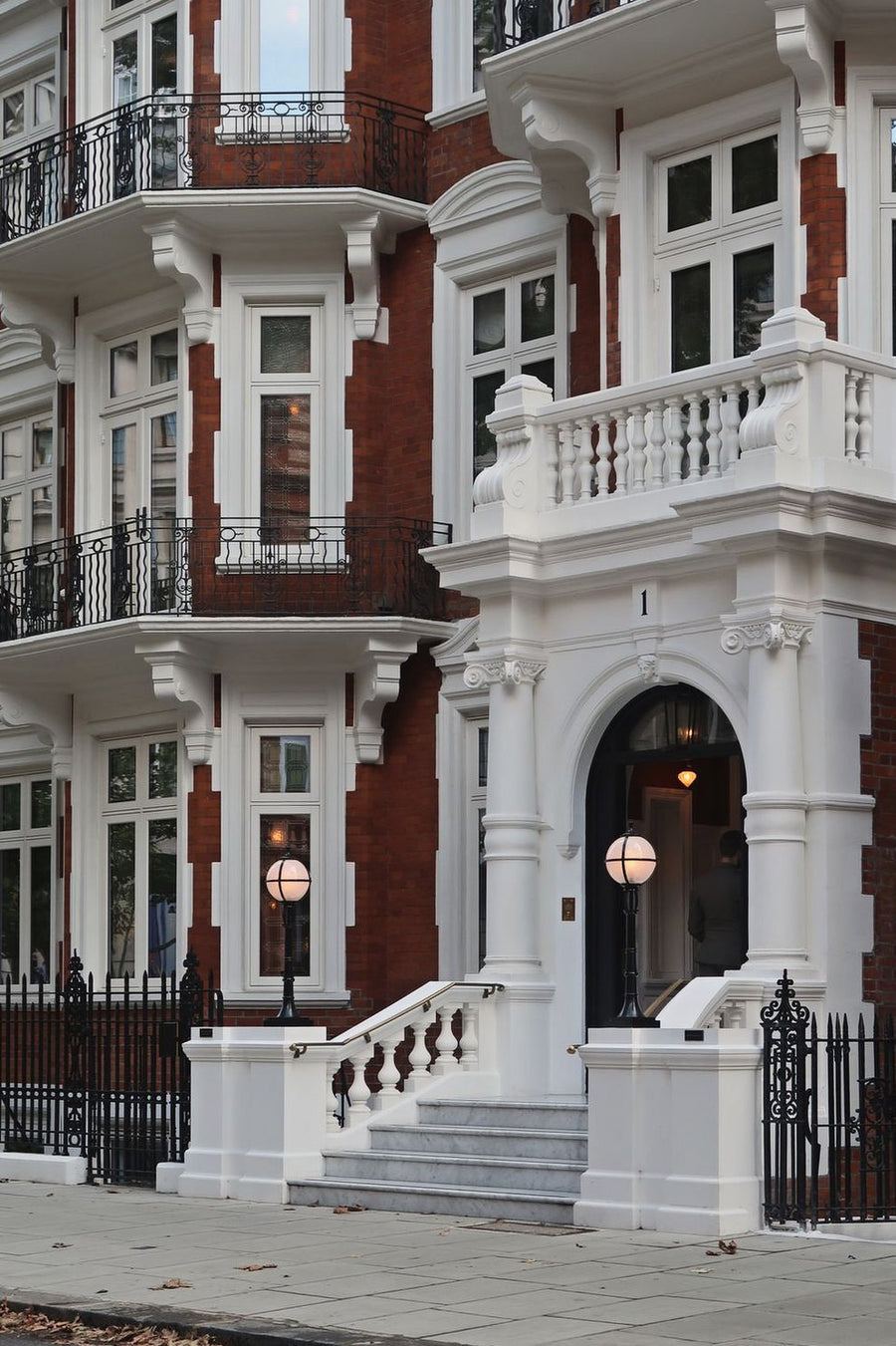A red brick townhouse with white balconies